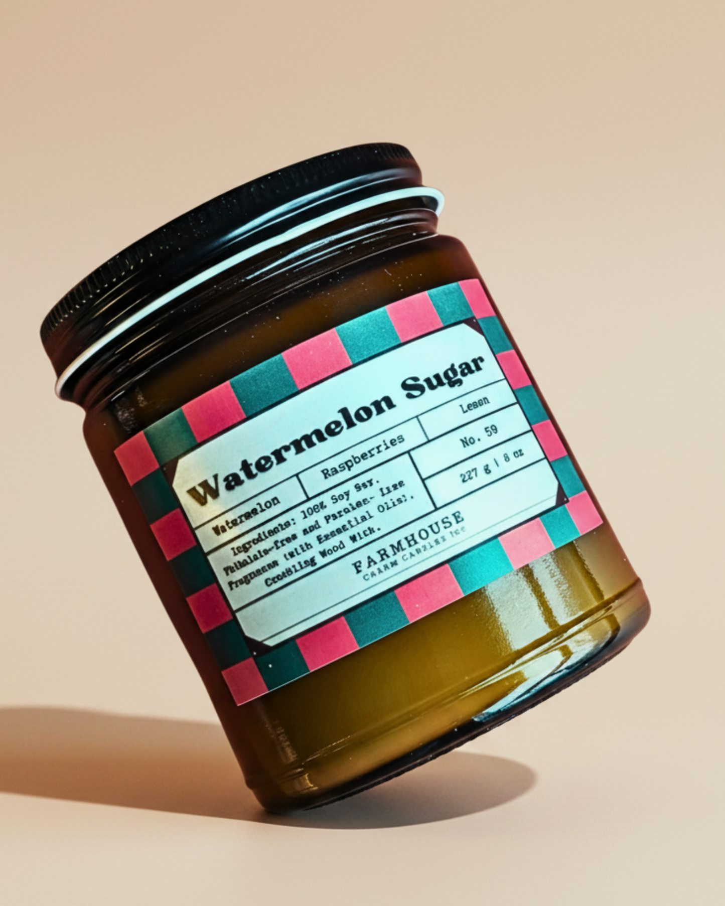 Jar of watermelon sugar soy candle by Farmhouse Charm Candles with a colorful label on a white background