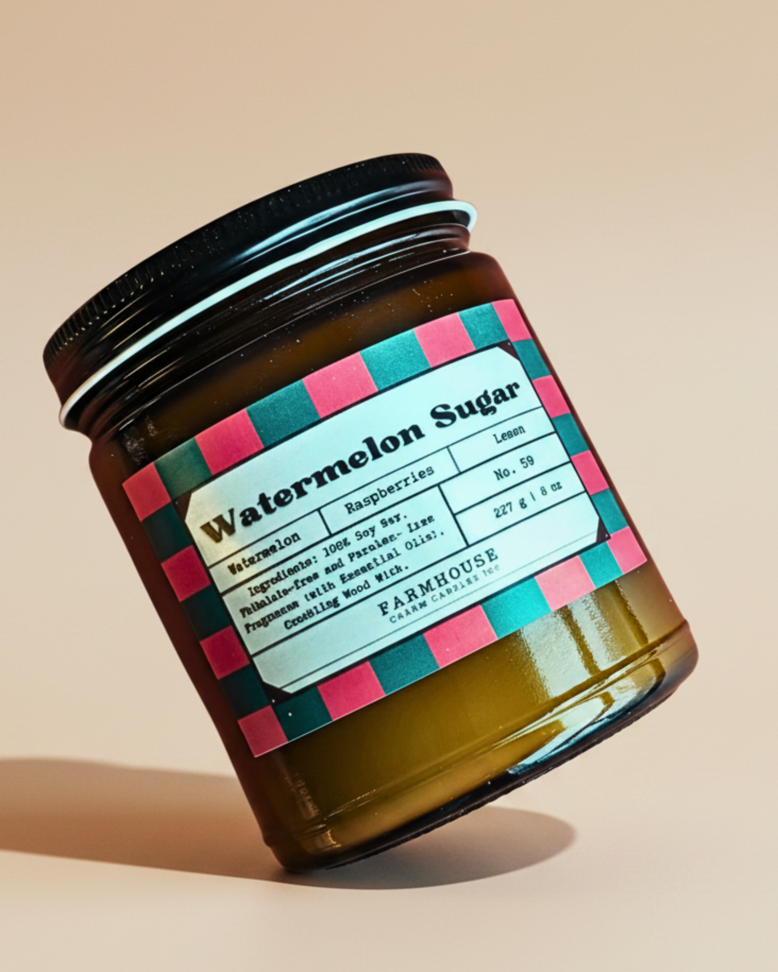 Jar of watermelon sugar soy candle by Farmhouse Charm Candles with a colorful label on a white background